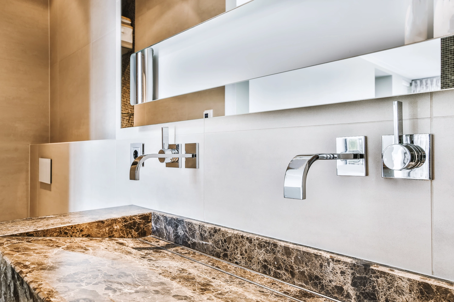 Close-up of a modern sink with chrome hardware and a natural stone bowl.