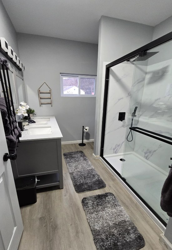 A stylish remodeled bathroom showcasing a shower, sink, and sleek fixtures in Warwick, RI