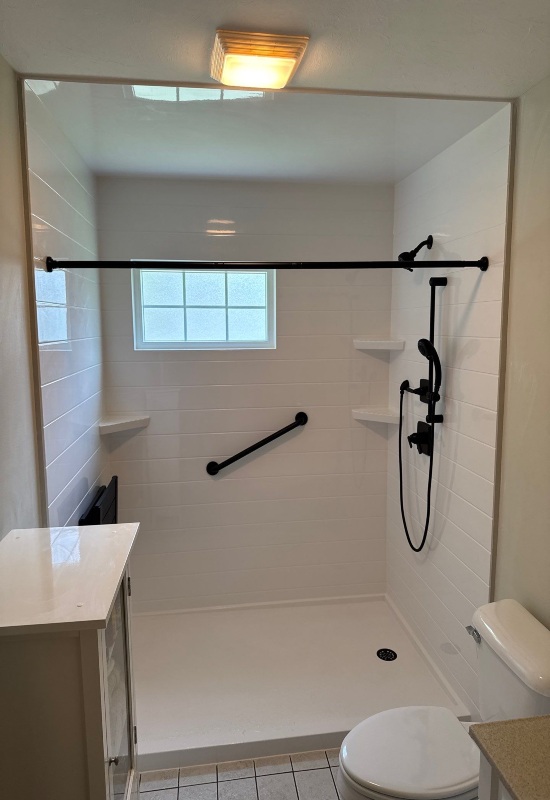 White bathtub in a modern bathroom, showcasing a recent remodel with fixtures in Franklin, MA