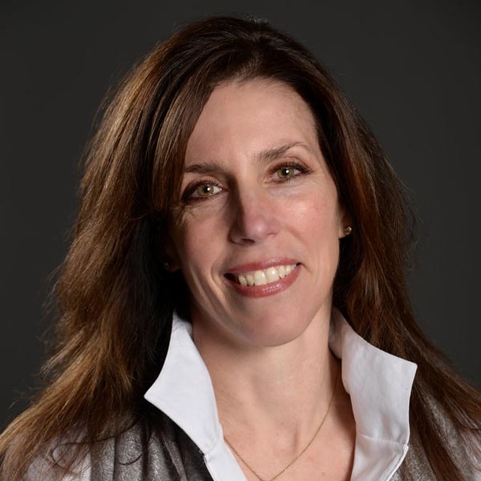 Portrait of company owner wearing a white shirt and gray jacket against a dark background in MA, RI, and Southern NH