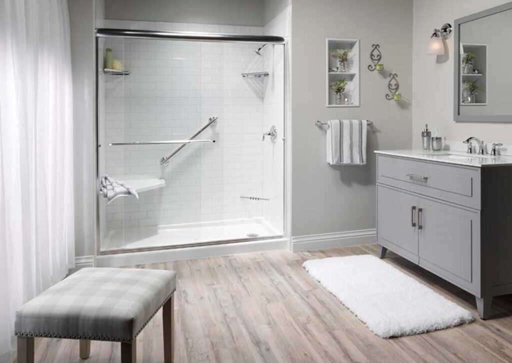 Stylish bathroom with walk-in shower, built-in bench, grab bars, light gray vanity, and wood-look flooring in MA, RI, and Southern NH