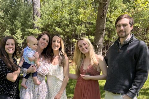 A family photo of the Bylo family in front of trees.