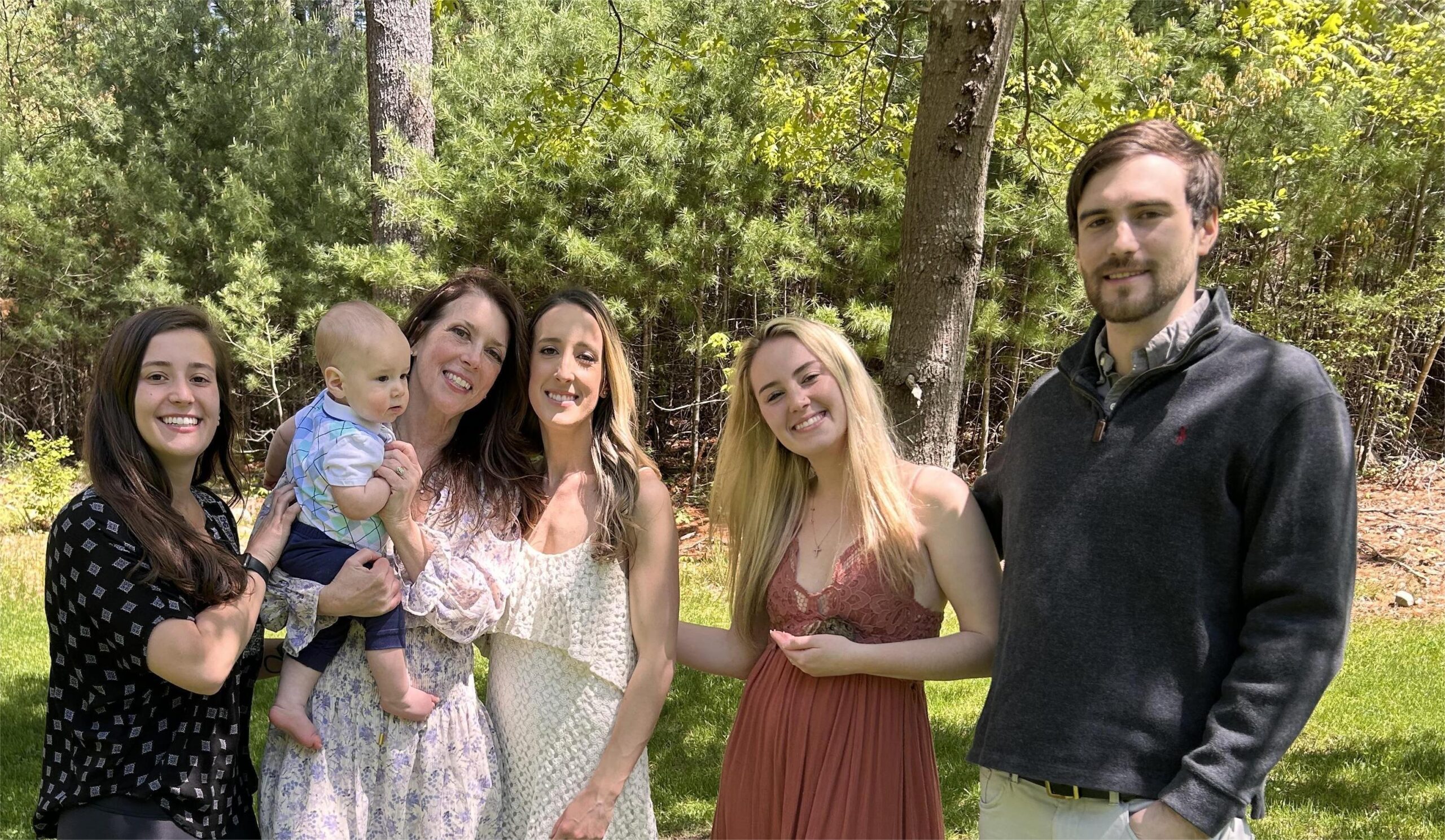 A family photo of the Bylo family in front of trees.